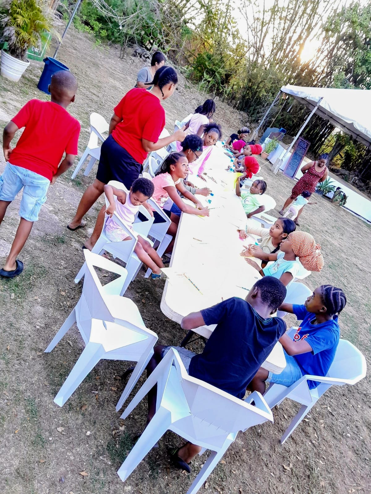 Children engaging in arts and crafts activities outdoors at an Arouca Soul Kitchen program